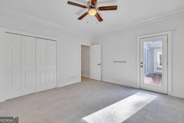 unfurnished bedroom featuring ceiling fan, light carpet, and ornamental molding