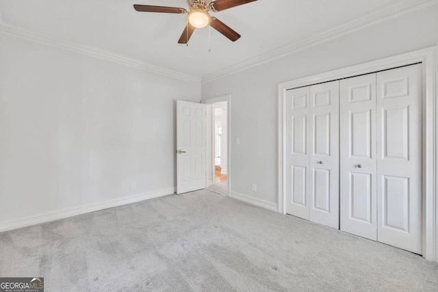 unfurnished bedroom with light carpet, ceiling fan, crown molding, and a closet