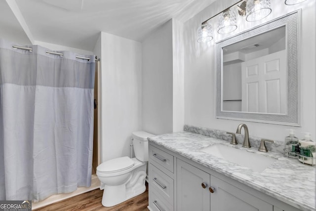 bathroom featuring toilet, a shower with curtain, vanity, and hardwood / wood-style flooring