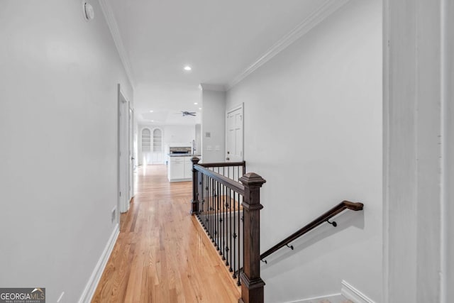 hallway featuring light wood-type flooring and crown molding