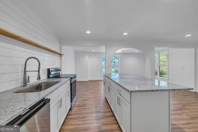 kitchen featuring stainless steel appliances, hardwood / wood-style flooring, white cabinets, and sink