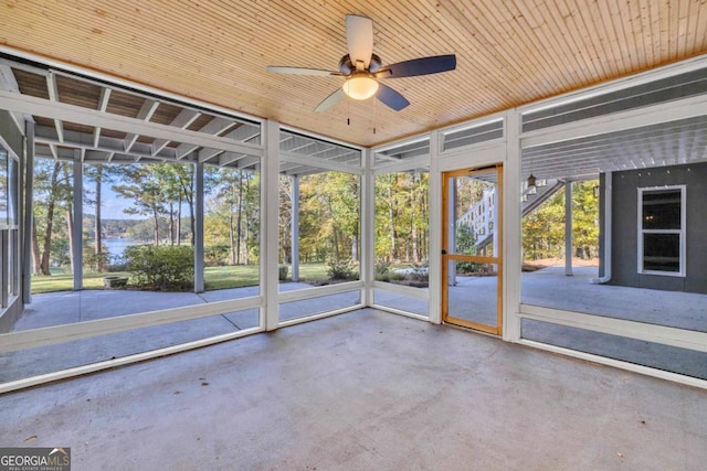 unfurnished sunroom featuring wooden ceiling and ceiling fan