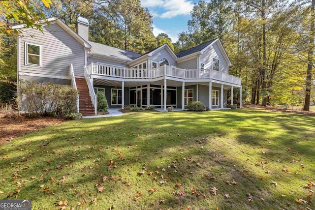 back of property with a lawn and a deck