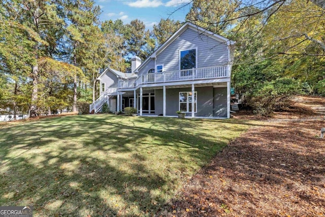 back of property with a wooden deck and a yard