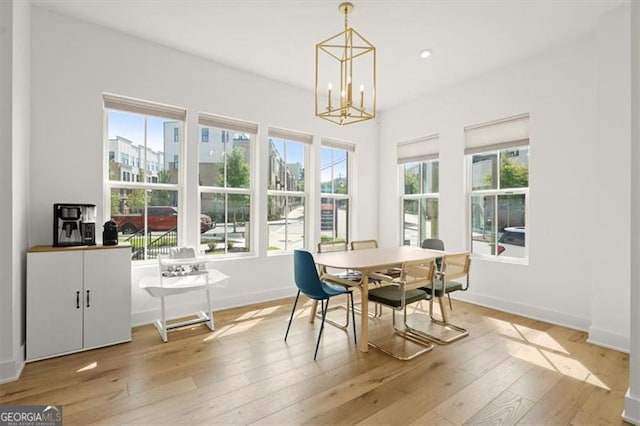 dining space featuring a notable chandelier and light hardwood / wood-style floors