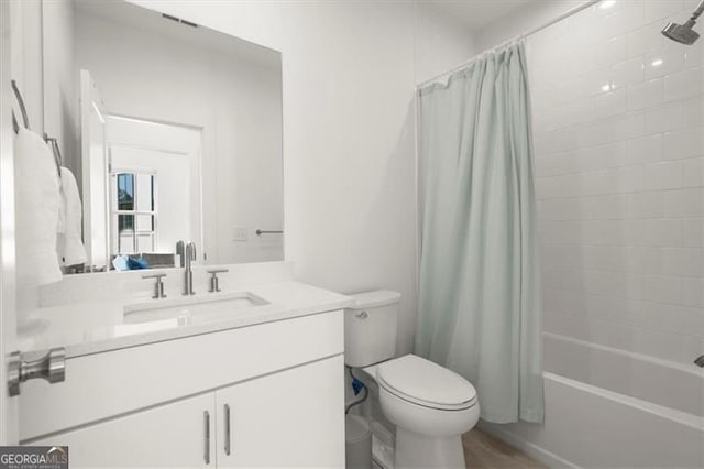 full bathroom featuring toilet, shower / tub combo with curtain, and vanity