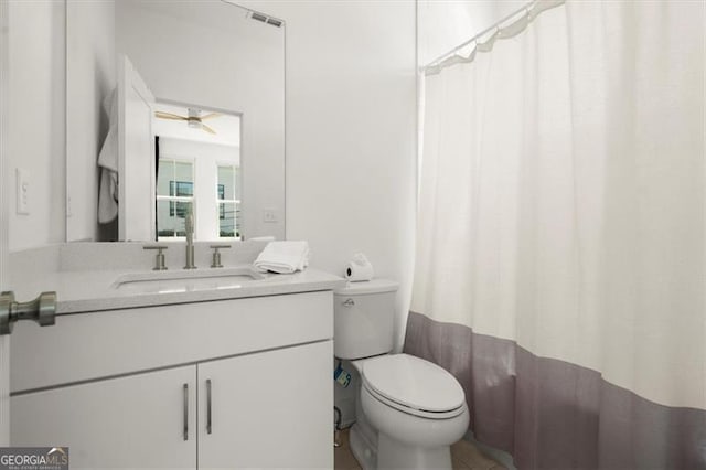 bathroom featuring a shower with curtain, ceiling fan, vanity, and toilet