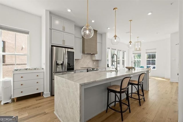 kitchen featuring sink, appliances with stainless steel finishes, a large island, and hanging light fixtures