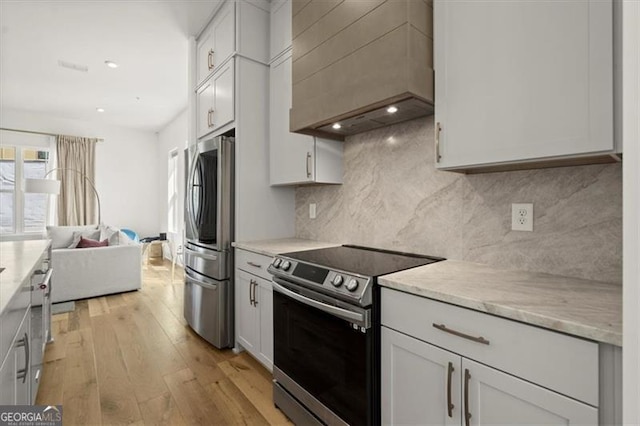 kitchen featuring white cabinets, light hardwood / wood-style floors, and appliances with stainless steel finishes