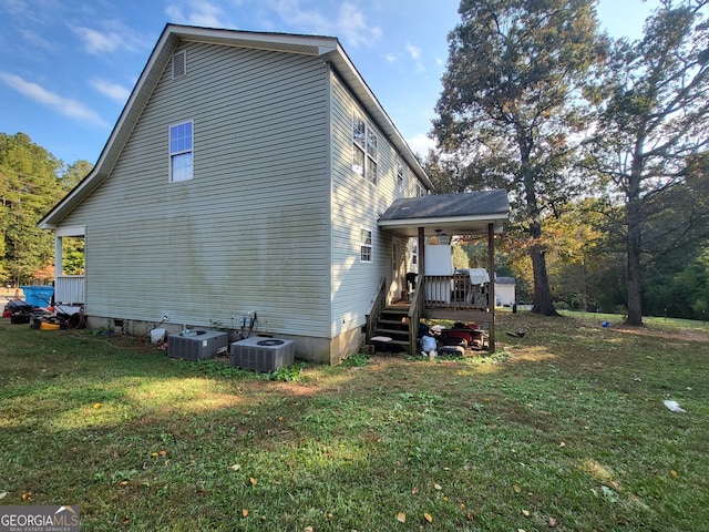 view of home's exterior with central air condition unit and a yard