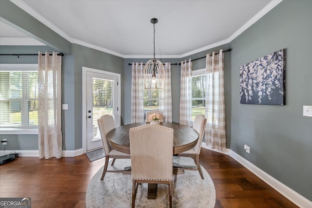 dining space with dark wood-type flooring, crown molding, and an inviting chandelier