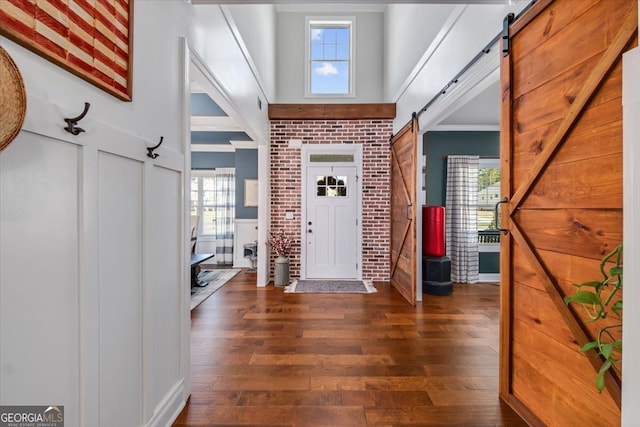 entrance foyer with a wealth of natural light, brick wall, and dark hardwood / wood-style floors