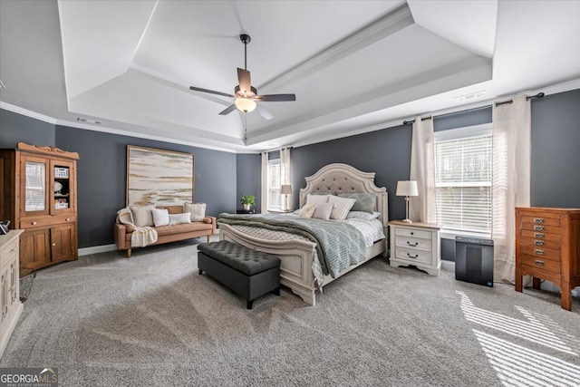 carpeted bedroom with crown molding, ceiling fan, and a raised ceiling