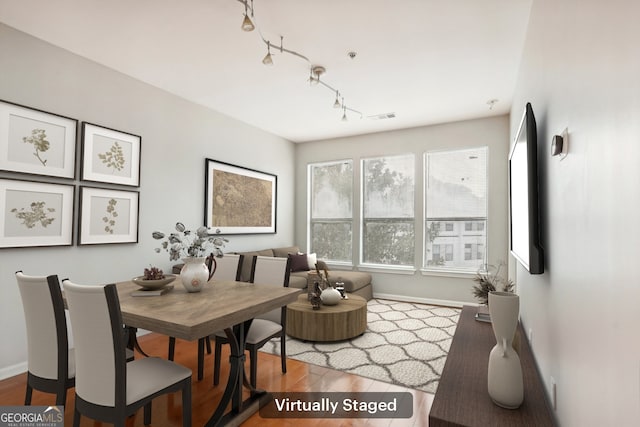 dining room featuring hardwood / wood-style flooring and rail lighting