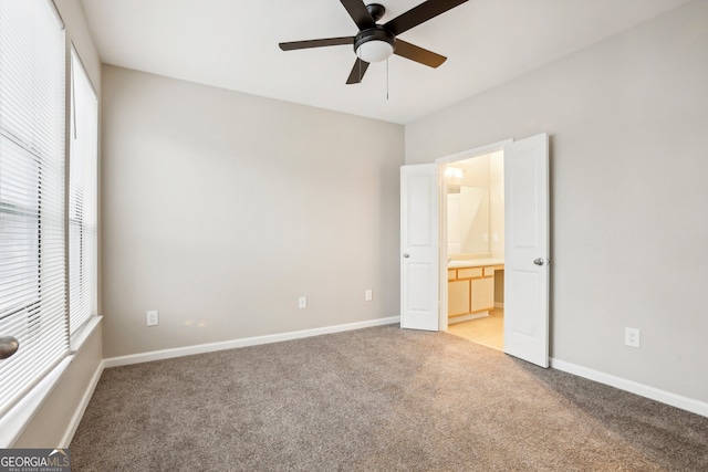 unfurnished bedroom featuring light carpet, ceiling fan, and ensuite bathroom