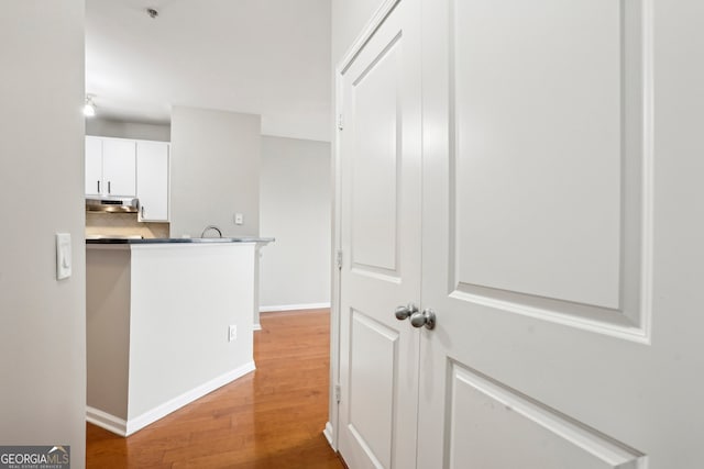 corridor with hardwood / wood-style flooring