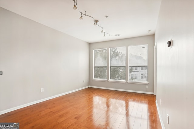 spare room with wood-type flooring and track lighting