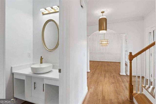 bathroom with hardwood / wood-style flooring, vanity, and crown molding