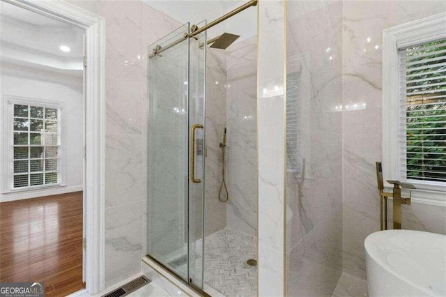 bathroom featuring wood-type flooring and separate shower and tub