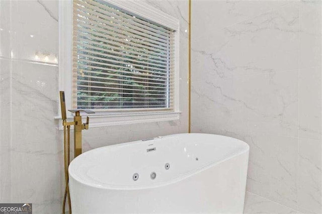 bathroom featuring tile walls and a bath