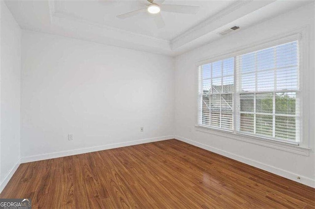 unfurnished room featuring a tray ceiling, wood-type flooring, and ceiling fan