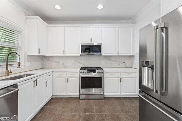 kitchen with white cabinetry, sink, backsplash, and appliances with stainless steel finishes