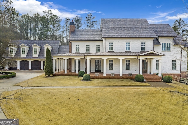 view of front facade with a garage, covered porch, and a front lawn