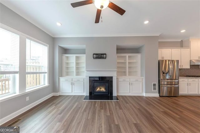 unfurnished living room with ornamental molding, hardwood / wood-style floors, and ceiling fan