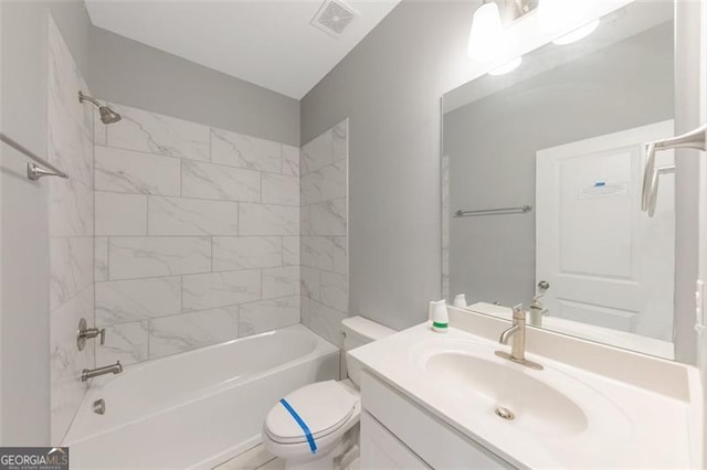 full bathroom featuring vanity, toilet, and tiled shower / bath