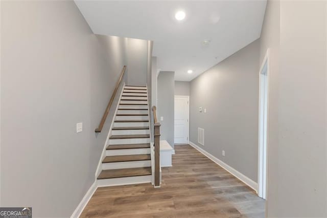 stairway with hardwood / wood-style floors