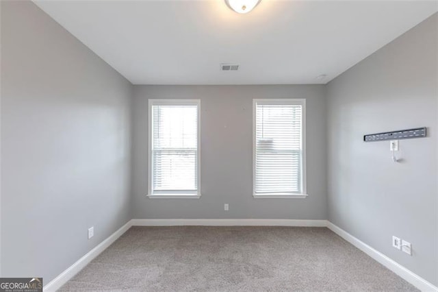 unfurnished room featuring light colored carpet