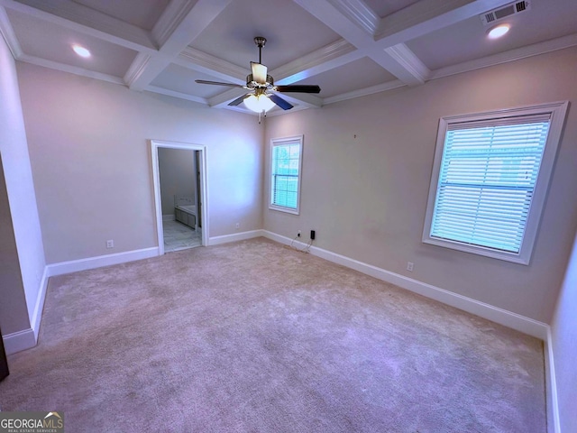 unfurnished bedroom with beamed ceiling, coffered ceiling, light colored carpet, crown molding, and ensuite bath