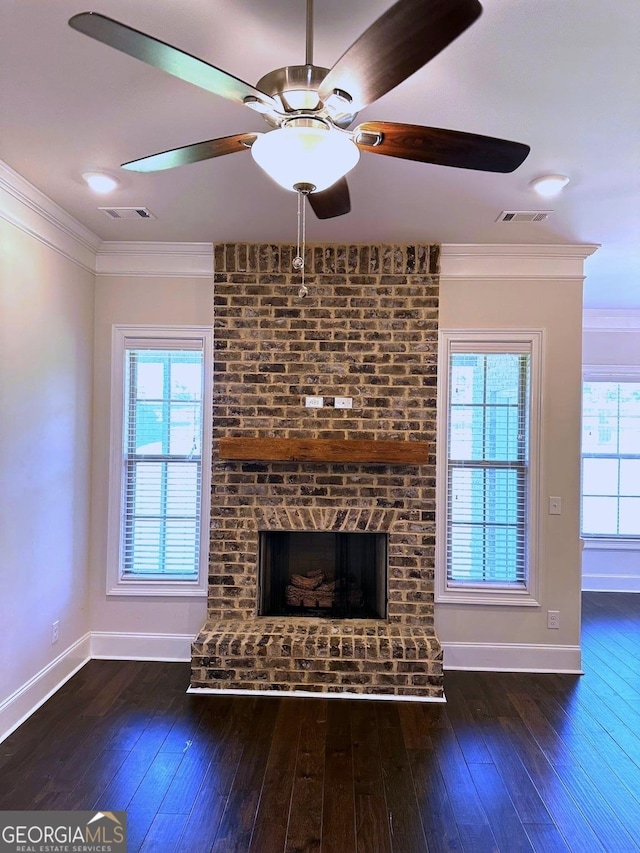 unfurnished living room featuring crown molding, dark hardwood / wood-style floors, and a brick fireplace