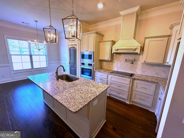 kitchen featuring premium range hood, sink, decorative light fixtures, appliances with stainless steel finishes, and a kitchen breakfast bar