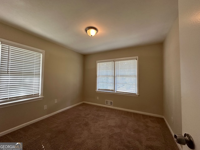 empty room with dark colored carpet