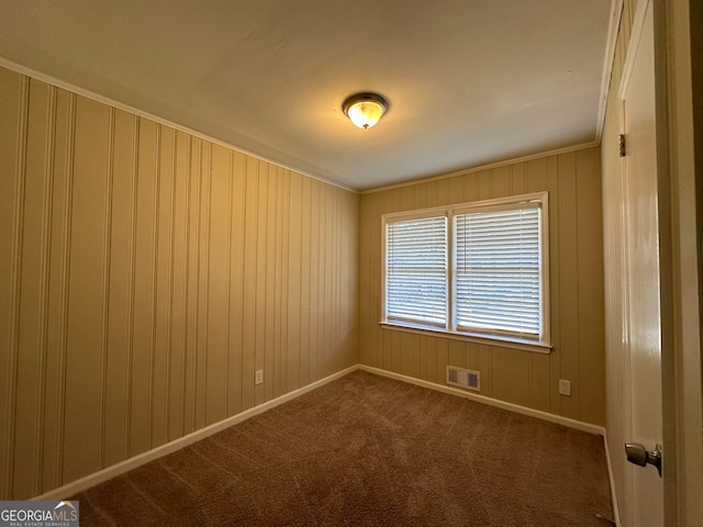 empty room featuring carpet flooring and ornamental molding