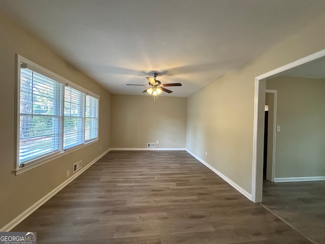 empty room with dark hardwood / wood-style flooring and ceiling fan