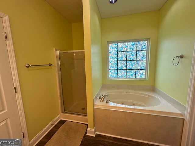 bathroom featuring hardwood / wood-style floors, shower with separate bathtub, and a textured ceiling