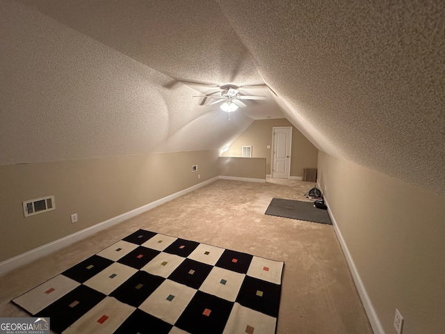 additional living space with ceiling fan, a textured ceiling, carpet flooring, and lofted ceiling