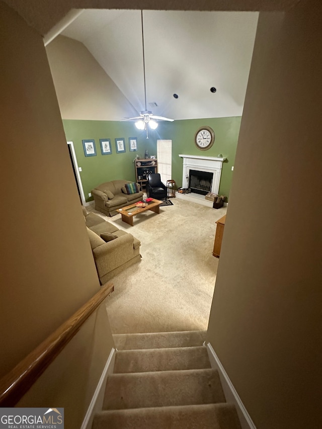 staircase with lofted ceiling, carpet flooring, and ceiling fan