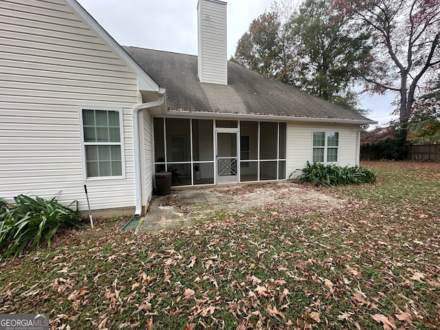 rear view of property featuring a sunroom