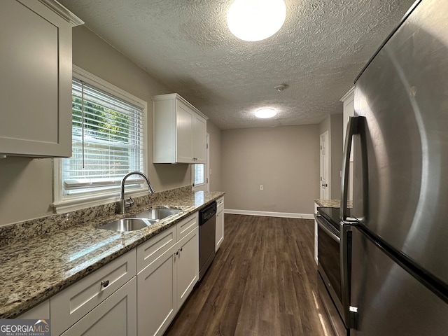 kitchen featuring dark hardwood / wood-style flooring, appliances with stainless steel finishes, sink, and white cabinets