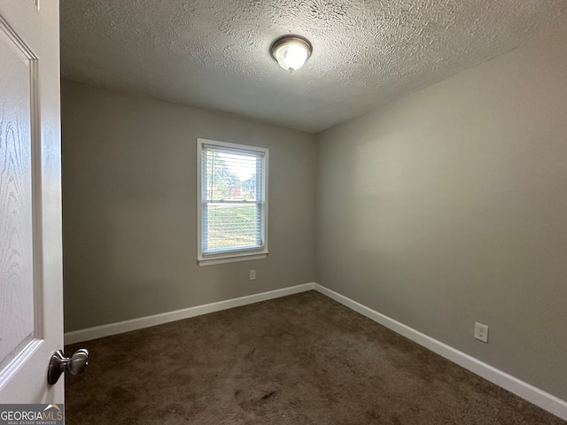 carpeted empty room featuring a textured ceiling