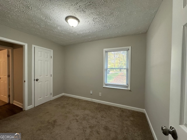 carpeted spare room featuring a textured ceiling