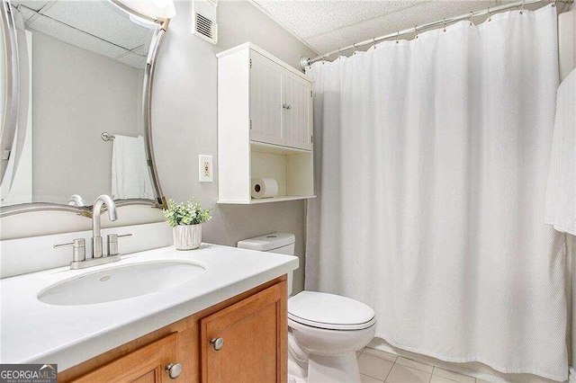 bathroom with tile patterned floors, toilet, curtained shower, a paneled ceiling, and vanity