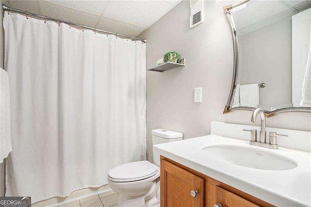 bathroom featuring toilet, vanity, a shower with shower curtain, and tile patterned floors