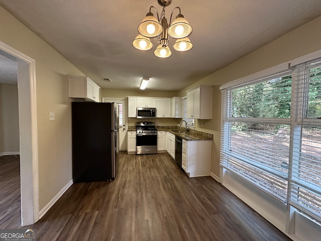 kitchen featuring stainless steel appliances, dark wood-type flooring, hanging light fixtures, sink, and white cabinetry