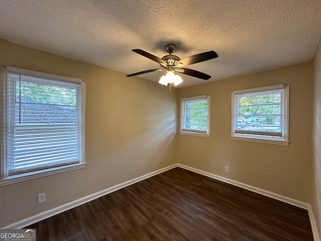 spare room with dark hardwood / wood-style flooring, a textured ceiling, and ceiling fan