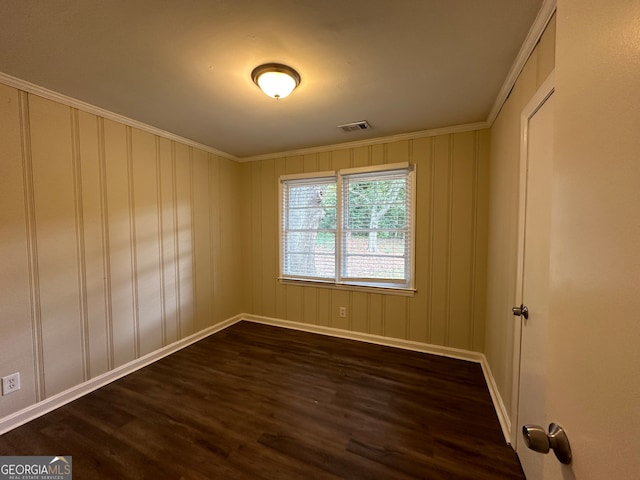 spare room featuring dark hardwood / wood-style floors and crown molding