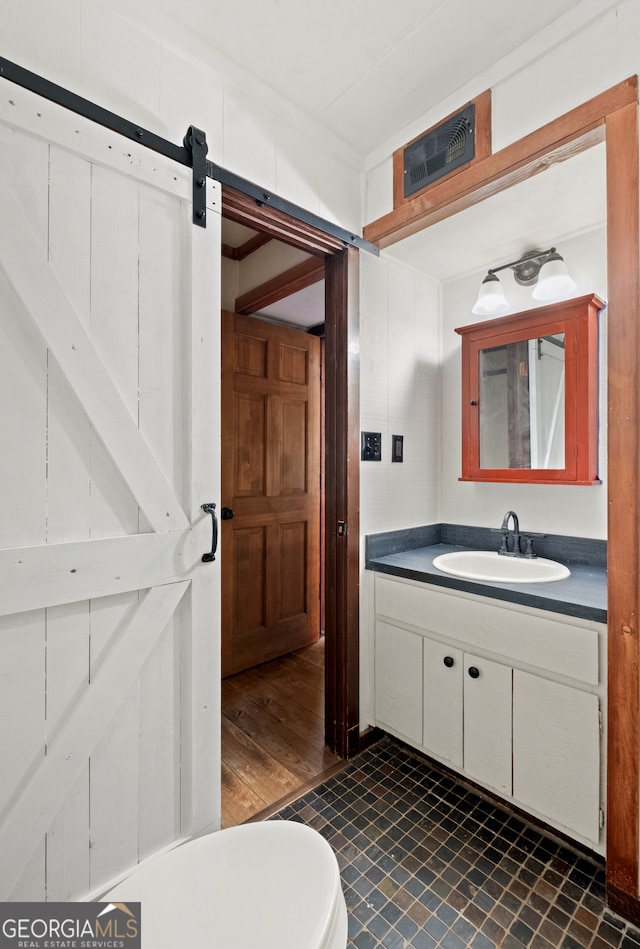 bathroom with hardwood / wood-style flooring, vanity, and toilet